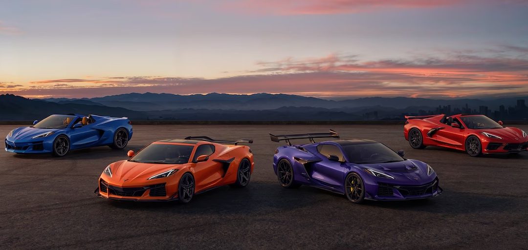Chevrolet Corvette lineup in multiple colors parked on open road at sunset
